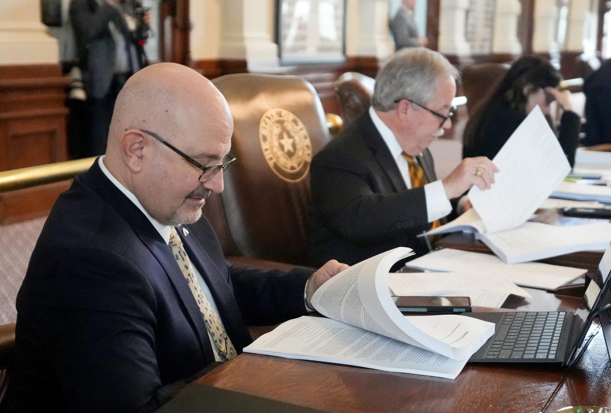 Reps. Jon Rosenthal, D-Houston, left, and Richard Hayes, R-Denton, look at the state budget Thursday on the House floor. The Texas Senate on Friday approved a $321.3 billion budget deal.
