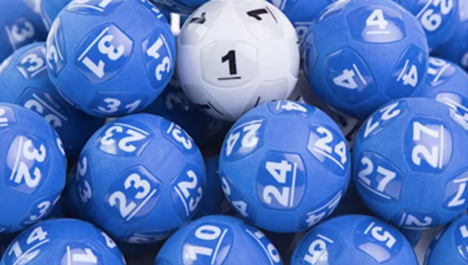 The white Powerball is nestled among other blue lottery balls.