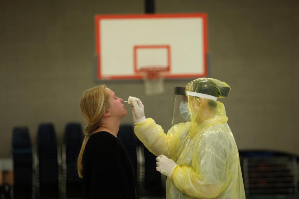 Hailey Boland, 20, a certified nursing assistant at John C. Fremont Hospital, receives a test for COVID-19 on the first day of testing for Mariposa residents at the Mariposa Alternative School Gym in Mariposa on April 30, 2020.