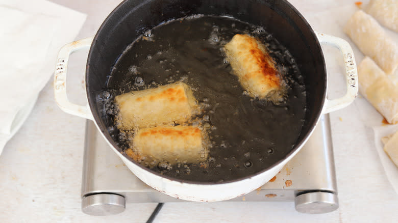 egg rolls fried in a pot