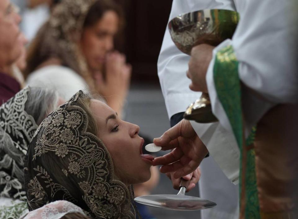 Una joven madre toma la comunión tradicionalmente mientras los congregantes de la Capilla de Nuestra Señora de Belén asistieron a la misa en latín del domingo por la mañana, en un servicio que atrajo a jóvenes fieles y familias, el domingo 30 de julio de 2023.