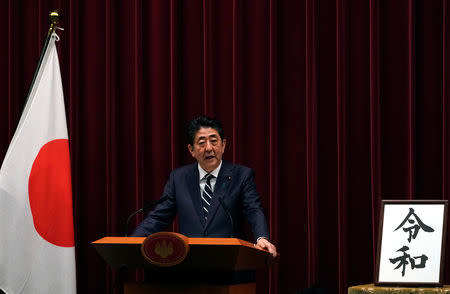Japan's Prime Minister Shinzo Abe delivers a press conference standing next to the calligraphy 'Reiwa' which was chosen as the new era name at the prime minister's office in Tokyo, Japan, April 1, 2019. Franck Robichon/Pool via Reuters