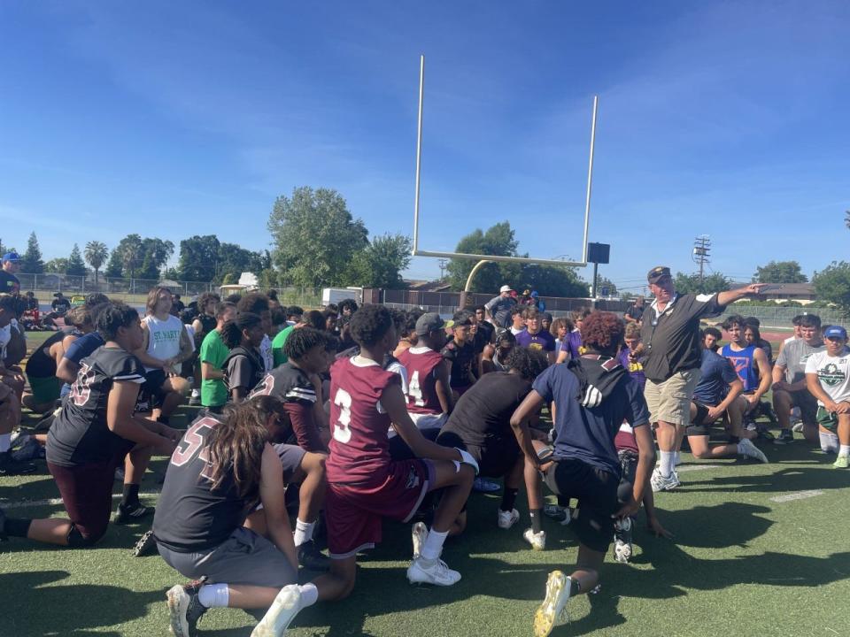 Players and coaches gather around Stagg football head coach Don Norton at the beginning of Stagg High School Football Showcase on May 17.