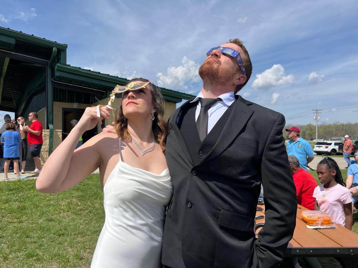 Local couple Samantha Palmer and Gerald Lester watched the sky minutes before tying the knot at Trenton’s Solar Eclipse Mass Wedding Ceremony officiated by Mayor Ryan Perry. Trenton Community Park. The park was filled with families and brides and grooms.