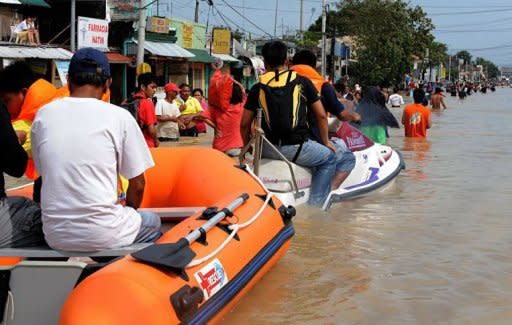 Residents use rafts and jet skies to travel down a street flooded in the aftermath of Typhoon Nalgae in Calumpit. The Philippines deployed helicopters, inflatable boats and amphibious vehicles Sunday in a desperate bid to evacuate tens of thousands in the aftermath of successive monster storms