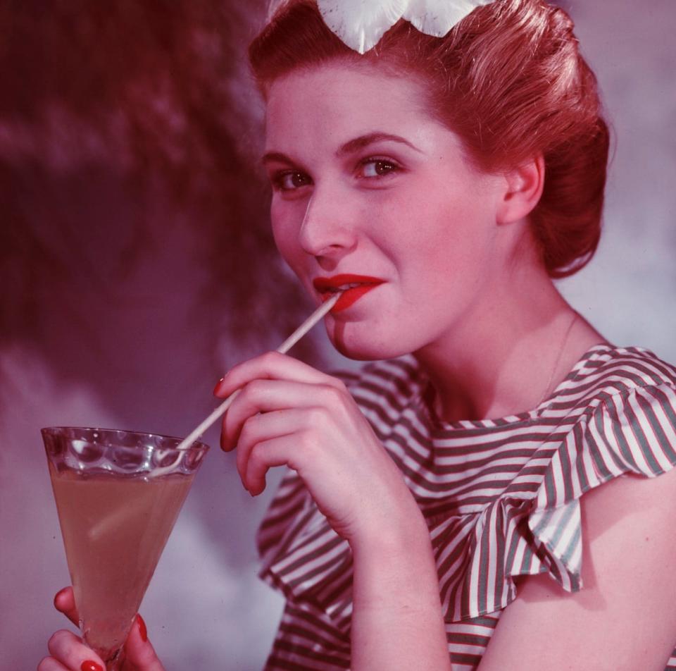 Woman drinking cocktail through straw c. 1950 - Science & Society Picture Library/SSPL/Getty Images