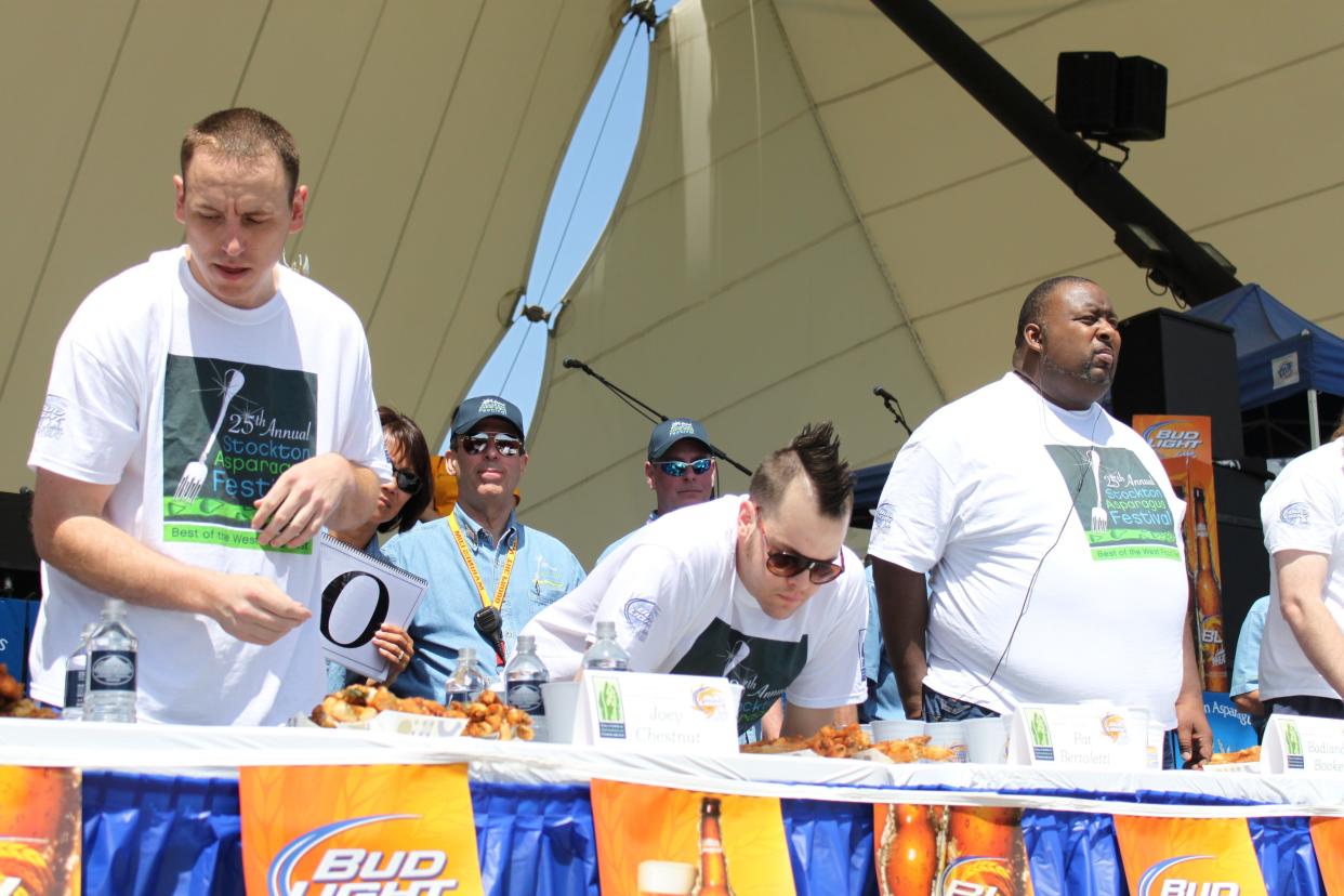 Joey Chestnut, Patrick Bertoletti and Badlands Booker at an eating competition.