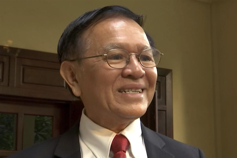In this image made from video, Cambodia's opposition leader Kem Sokha speaks to the media on steps of his home before leaving for his trial in Phnoem Penh, Wednesday, Jan. 15, 2020. The trial of the top Cambodian opposition leader charged with treason began Wednesday, more than two years after he was arrested in what is widely seen as a politically motivated prosecution. (APTN via AP)