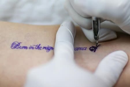 Suthida Rojanapanyawong is tattooed to honour Thailand's late King Bhumibol Adulyadej, at a tattoo shop in Bangkok, Thailand, October 18, 2016. Tattoo reads "Born in the reign of King Rama IX". REUTERS/Athit Perawongmetha