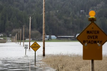 Partially-submerged signs are pictured as flood waters of the Snoqualmie River cover NE 80th Street during a storm in Carnation, Washington December 9, 2015. REUTERS/Jason Redmond