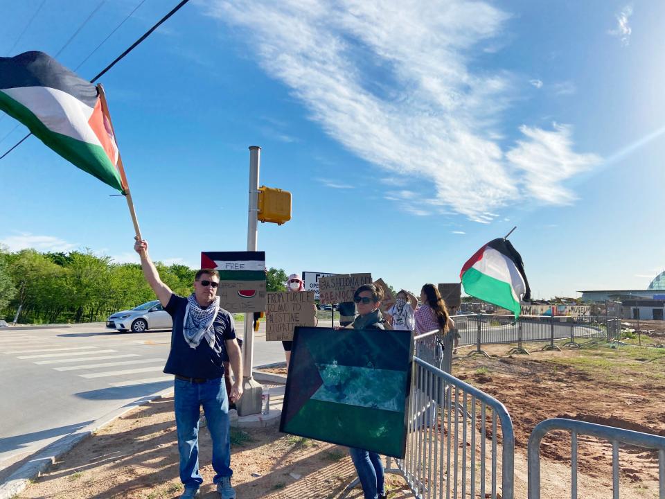 People wave Palestinian flags and hold up signage and art during an Indigenous Liberation Collective demonstration at the entrance to the First Americans Museum to protest Oklahoma Israel Exchange's "Fashionably Tied" event at the museum in Oklahoma City.