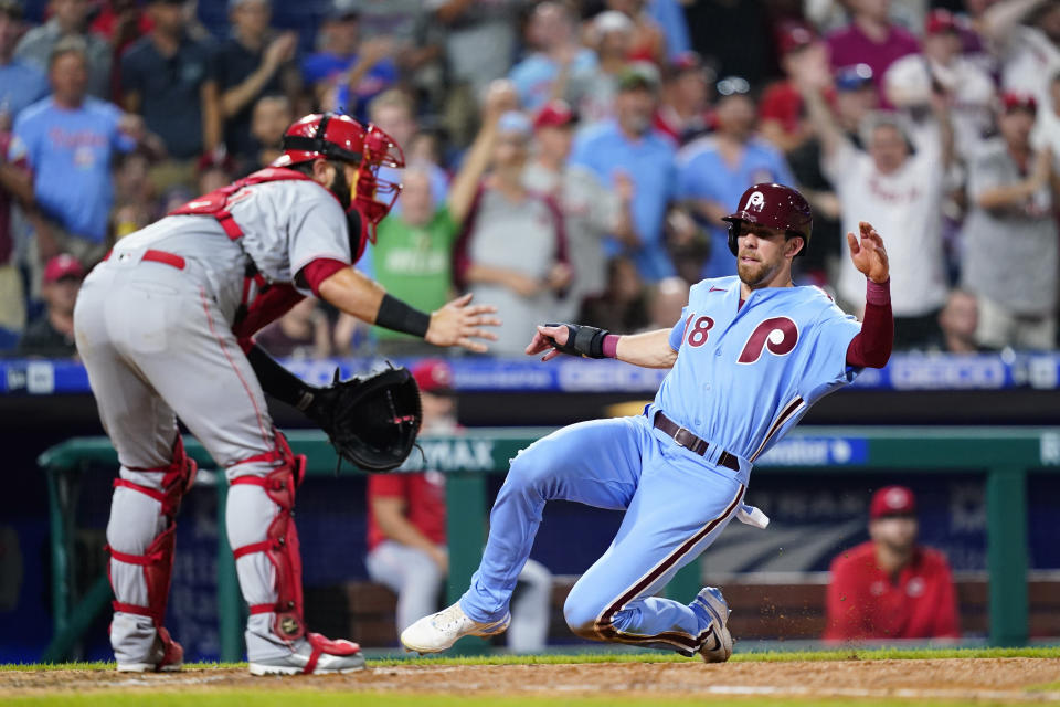 Philadelphia Phillies' Bradley Zimmer, right, scores past Cincinnati Reds catcher Austin Romine on a two-run single by Edmundo Sosa during the seventh inning of a baseball game, Thursday, Aug. 25, 2022, in Philadelphia. (AP Photo/Matt Slocum)