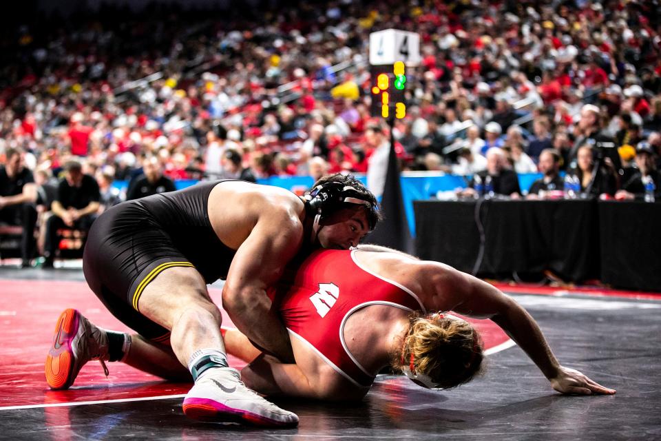 Iowa's Tony Cassioppi, top, wrestles Wisconsin's Trent Hillger at 285 pounds on Saturday.