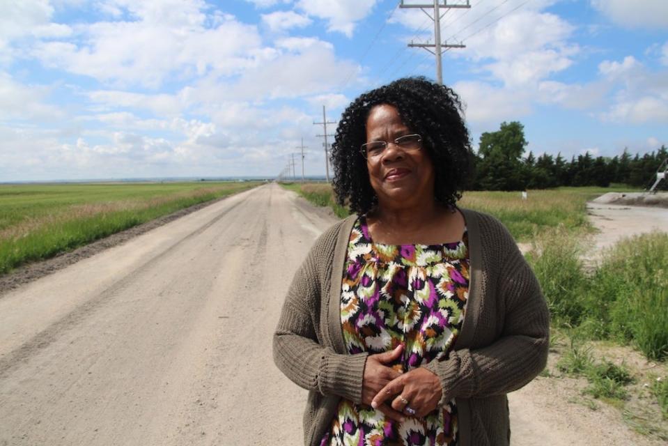 JohnElla Holmes, president and executive director of the Kansas Black Farmers Association, stands next to a piece of farmland north of Nicodemus.