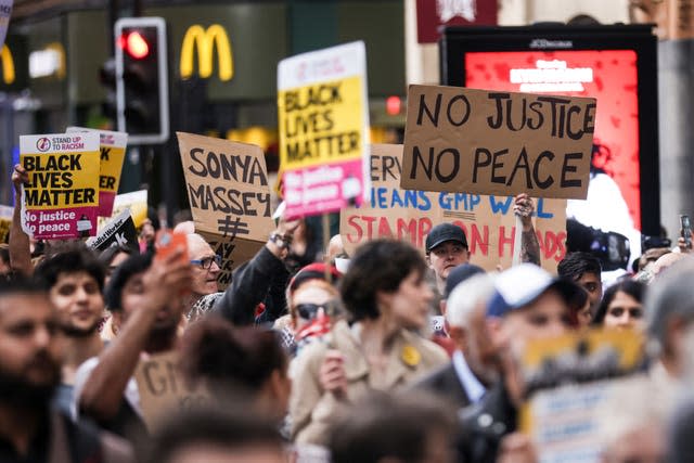 Protesters hold up placards during a Stand Up To Racism demonstration in Manchester