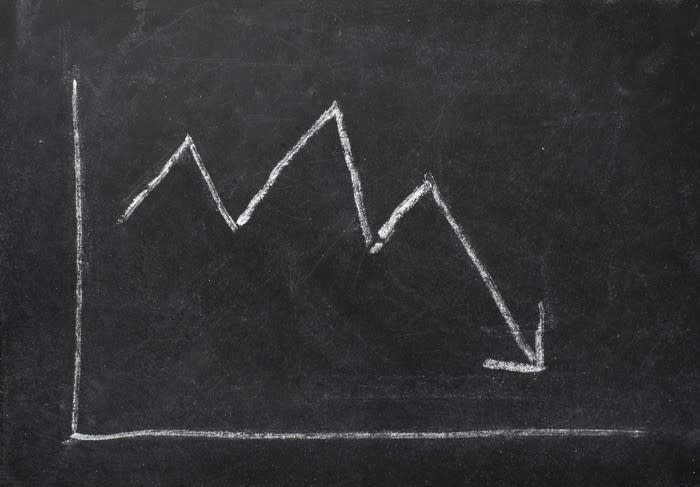 A chalkboard sketch of a chart with a downward-sloping arrow.