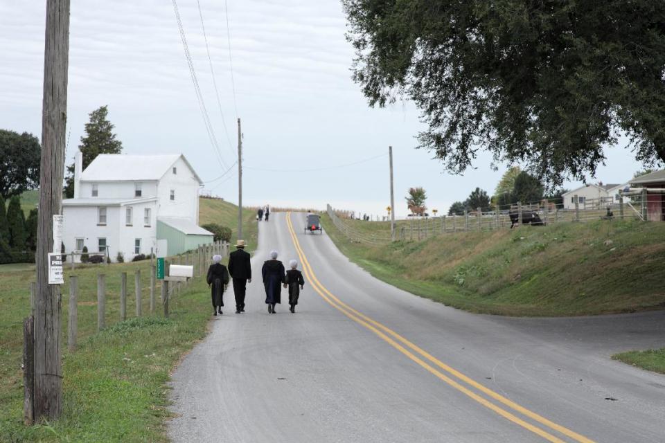 In this image released by PBS, a family walks to church in a scene from "The Amish: American Experience," a film that offers a revealing look at the Amish community of about 250,000 centered primarily in rural Pennsylvania, Ohio and Indiana. The film premieres on PBS stations on Feb. 28 at 8 p.m. (AP Photo/PBS)