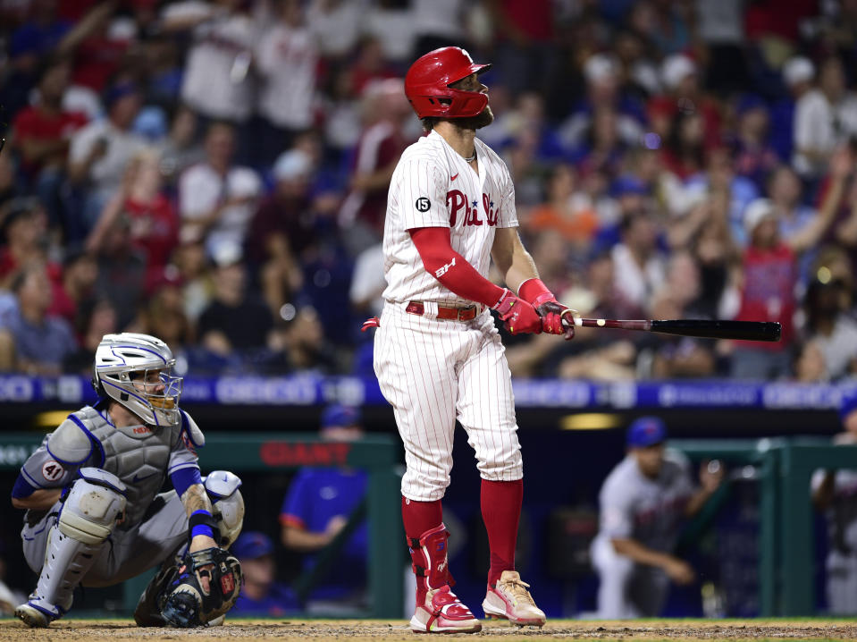 Philadelphia Phillies' Bryce Harper, right, watches his two-run home run off New York Mets' Yennsy Diaz during the eighth inning of a baseball game, Friday, Aug. 6, 2021, in Philadelphia. (AP Photo/Derik Hamilton)