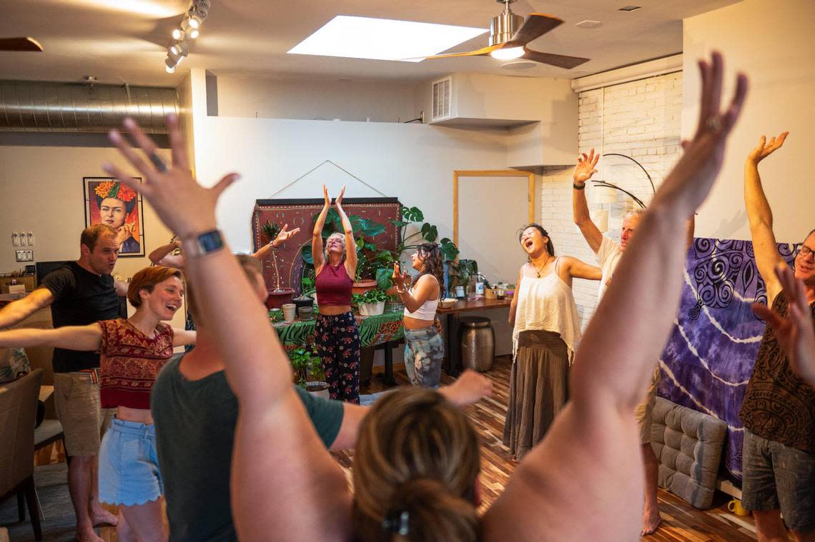 Laugher yoga students stretch and laugh together at Cafe Gratitude on Monday in Kansas City. “The purest human is the child, the baby,” Kalima said. “So when we get in contact with that aspect, it reminds us what it felt like to be trusting and to be joyful hearted.” Zachary Linhares/zlinhares@kcstar.com