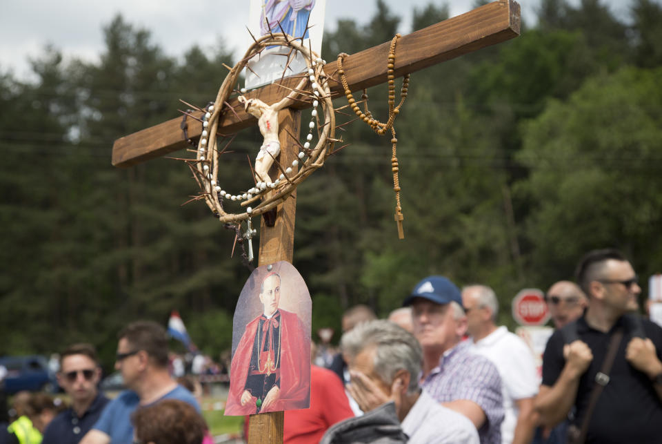 FILE - In this Saturday, May 12, 2018 file photo, a mourner holds a crucifix during a commemoration ceremony in Bleiburg, Austria. Thousands will gather in a field in southern Austria on Saturday, May 18, 2018, for an annual event to commemorate the massacre of tens of thousands mostly pro-Nazi soldiers known as Ustashas who fled to the village of Bleiburg in May 1945 amid a Yugoslav army offensive, only to be turned back by the British military and into the hands of revengeful antifascists. (AP Photo/Darko Bandic, File)