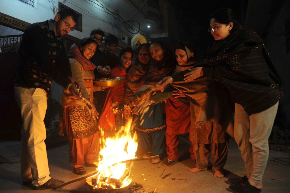 People from the Sikh community gather around a fire to celebrate the winter festival of Lohri in Punjab’s Amritsar city (AFP via Getty Images)