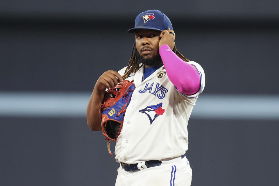 Toronto Blue Jays first baseman Vladimir Guerrero Jr. clasps his left ear as he stands at the base during the eighth inning of the team's baseball game against the Boston Red Sox on Friday, Sept. 15, 2023, in Toronto. (Chris Young/The Canadian Press via AP)