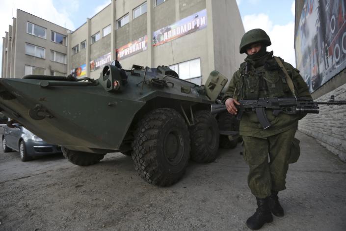 A soldier in an unmarked uniform stands guard at APC outside the Ukrainian Military Prosecutor's Office in Simferopol, Crimea, Thursday, March 20, 2014. The lower house of Russian parliament voted Thursday to make Crimea a part of Russia following Sunday’s Crimean referendum in which its residents overwhelmingly backed breaking off from Ukraine and joining Russia. (AP Photo/Maxin Vetrov)