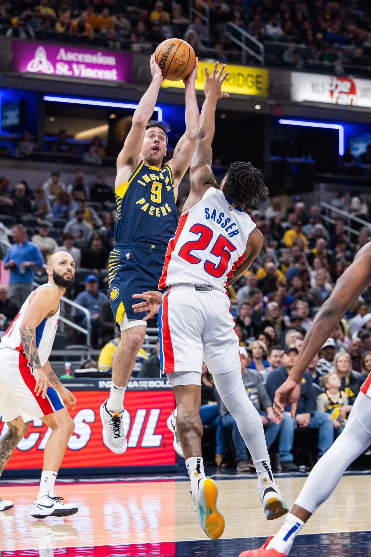 Feb 22, 2024; Indianapolis, Indiana, USA; Indiana Pacers guard T.J. McConnell (9) shoots the ball while Detroit Pistons guard Marcus Sasser (25) defends in the second half at Gainbridge Fieldhouse. Mandatory Credit: Trevor Ruszkowski-USA TODAY Sports