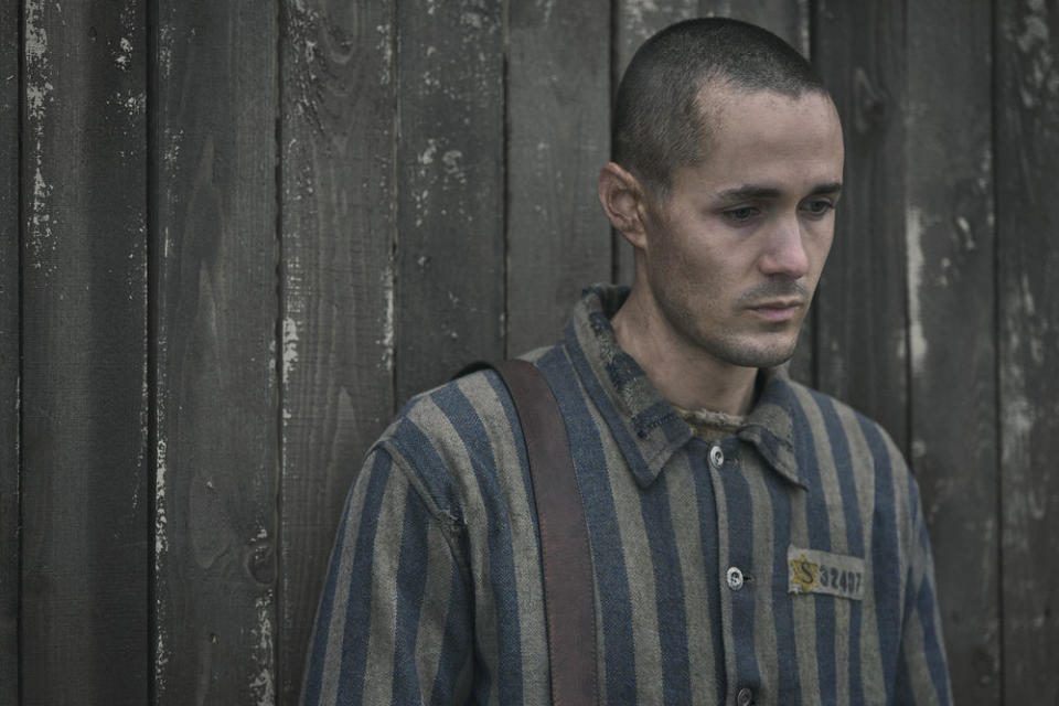 Man in striped prison uniform with ID number, looking contemplative. Used in a TVAndMovies article