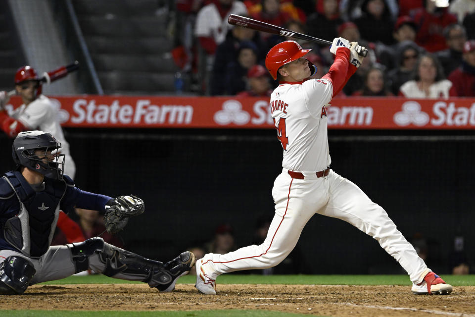 Los Angeles Angels' Logan O'Hoppe follows through on a grand slam next to Boston Red Sox catcher Reese McGuire during the sixth inning of a baseball game in Anaheim, Calif., Friday, April 5, 2024. (AP Photo/Alex Gallardo)