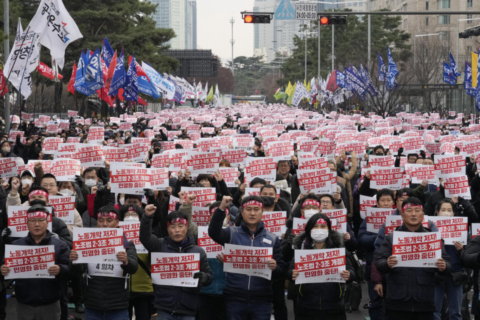 Members of the Korean Confederation of Trade Unions hold up their cards during a rally against the government's labor policy near the National Assembly in Seoul, South Korea, Saturday, Dec. 3, 2022. Thousands of demonstrators representing organized labor marched in South Korea's capital on Saturday denouncing government attempts to force thousands of striking truckers back to work after they walked out in a dispute over the price of freight. The cards read "Stop the worsening of labor laws." (AP Photo/Ahn Young-joon)