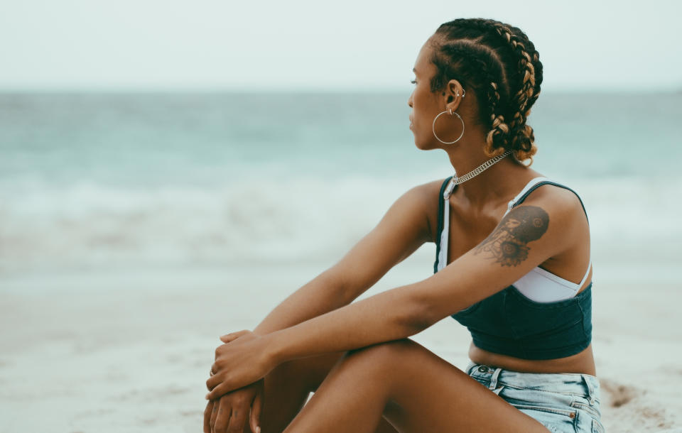 Shot of a young woman sitting and resting on the beach