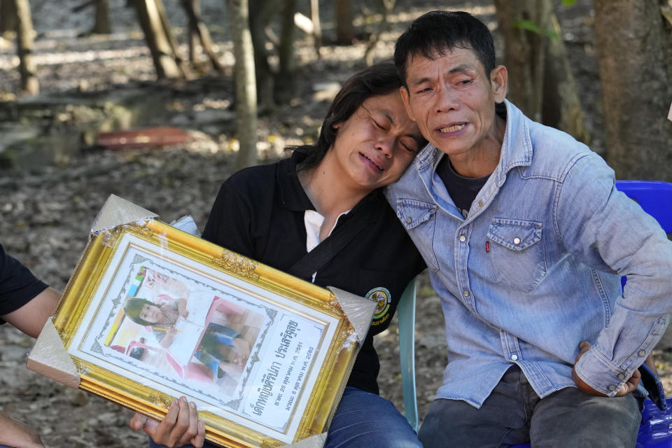 Tukta Wongsila grieves with her father Saart as holds her daughter Siriprapa “Plai Fon” Prasertsuk's picture, one of the many victims of a mass killing attack in the rural town of Uthai Sawan, north eastern Thailand, Friday, Oct. 7 , 2022. A former police officer burst into a day care center in northeastern Thailand on Thursday, killing dozens of preschoolers and teachers before shooting more people as he fled. (AP Photo/Sakchai Lalit)