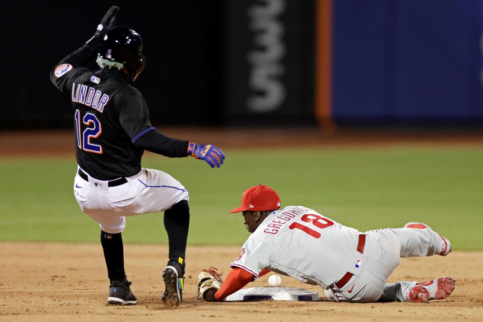 New York Mets' Francisco Lindor (12) is safe at second base as Philadelphia Phillies shortstop Didi Gregorius (18) can't handle the throw during the eighth inning of a baseball game on Friday, April 29, 2022, in New York.