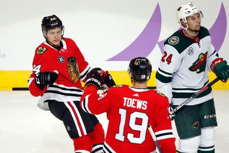 Nov 18, 2018; Chicago, IL, USA; Chicago Blackhawks center Jonathan Toews (19) congratulates Chicago Blackhawks center Dominik Kahun (24) after scoring as Minnesota Wild defenseman Matt Dumba (24) looks on uring the third period at United Center. The Chicago Blackhawks won 3-1. Mandatory Credit: Jon Durr-USA TODAY Sports