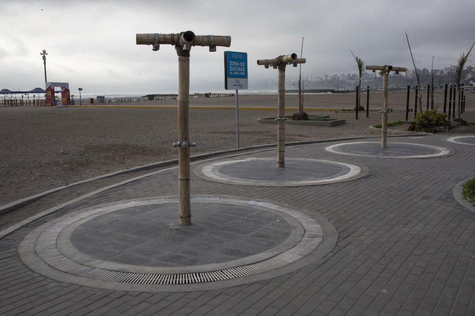 This March 25, 2020 photo shows a row of public showers typically overflowing with beachgoers, at Agua Dulce beach in Lima, Peru. (AP Photo/Rodrigo Abd)