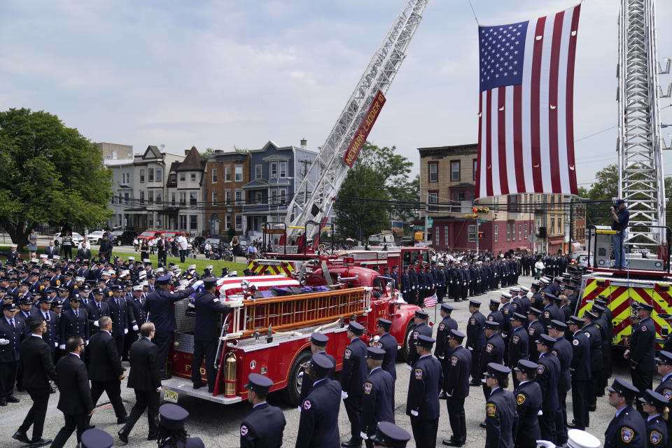 The casket of Newark firefighter Augusto "Augie" Acabou departs aboard a firetruck hearse after being carried from the Cathedral Basilica of the Sacred Heart during his funeral days after he died battling a fire aboard the Italian-flagged Grande Costa d'Avorio cargo ship at the Port of Newark, Thursday, July 13, 2023, in Newark, N.J. The fire also claimed the life of Wayne "Bear" Brooks Jr. (AP Photo/John Minchillo)