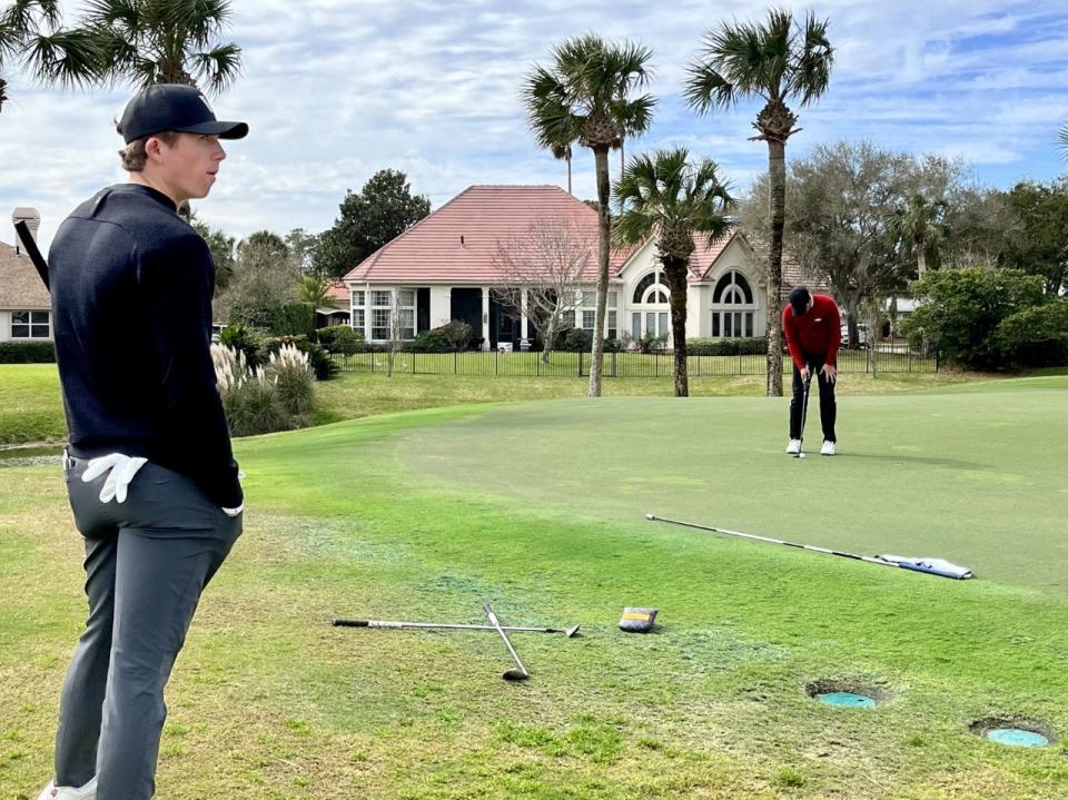 Defending NCAA individual champion Gordon Sargent (left) waits off the 16th green of the Sawgrass Country Club while playing partner Mateo Fernandez De Olivera of Arkansas putts out in the first round of The Hayt.