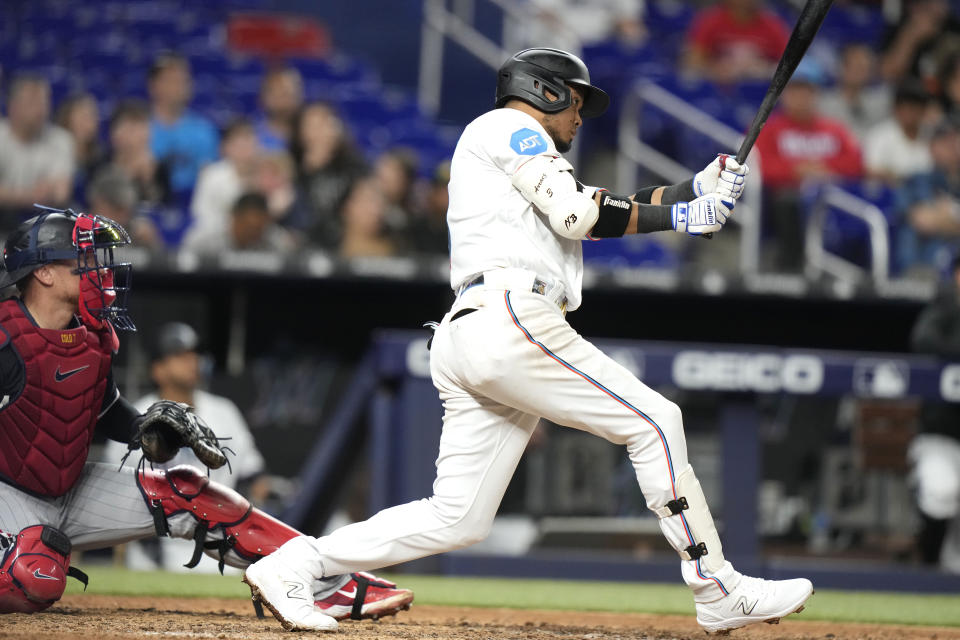 Miami Marlins' Luis Arraez, right, follows through on a single during the eighth inning of a baseball game against the Minnesota Twins, Monday, April 3, 2023, in Miami. (AP Photo/Lynne Sladky)