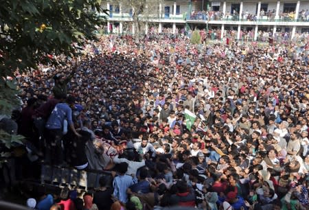 Kashmiri men gather around the body of Nasir Ahmad, a suspected separatist militant, during his funeral after he was killed in a gun battle with Indian soldiers, in Arwani village