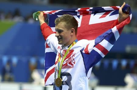 2016 Rio Olympics - Swimming - Victory Ceremony - Men's 100m Breaststroke Victory Ceremony - Olympic Aquatics Stadium - Rio de Janeiro, Brazil - 07/08/2016. Adam Peaty (GBR) of United Kingdom poses with the Union Jack flag after winning the gold. REUTERS/Michael Dalder