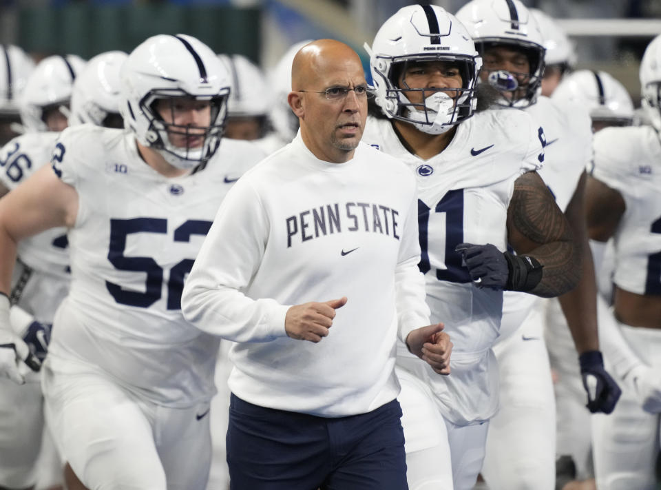 FILE - Penn State head coach James Franklin, center, runs out with his team before an NCAA college football game against Michigan State, Nov. 24, 2023, in Detroit. An internal review by Penn State in 2019 found evidence of “friction” between football coach James Franklin and a now-former team doctor. However, it could not determine whether Franklin violated NCAA rules or Big Ten standards by interfering with medical decisions. (AP Photo/Carlos Osorio, File)