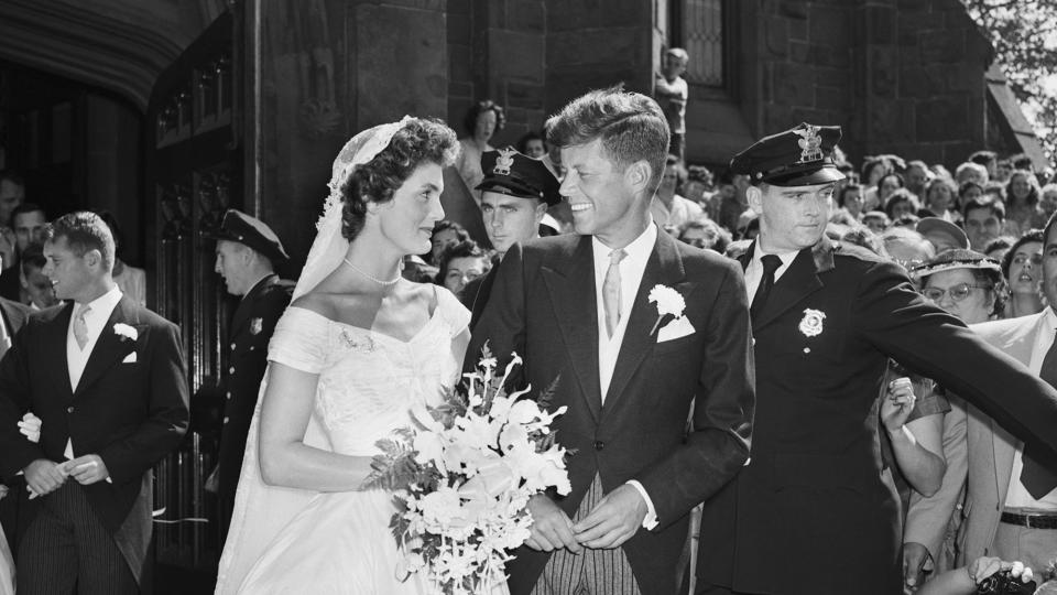 Senator John F. Kennedy and his bride, the former Jacqueline Lee Bouvier, leave a Newport, Rhode Island, church following their wedding ceremony. An estimated one thousand people waited outside the church for the newlyweds.