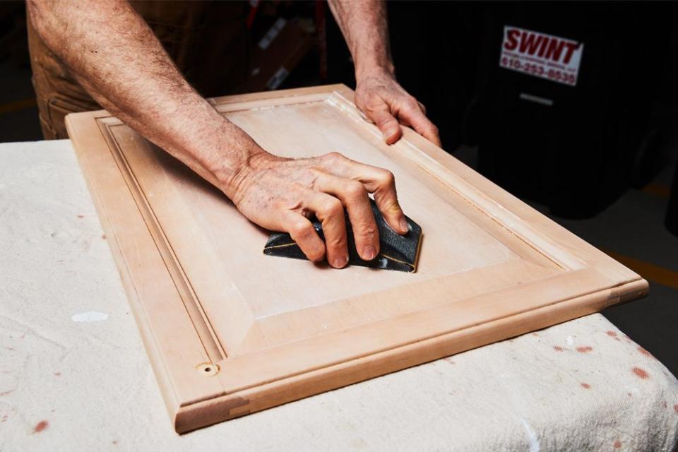 sanding a kitchen cabinet