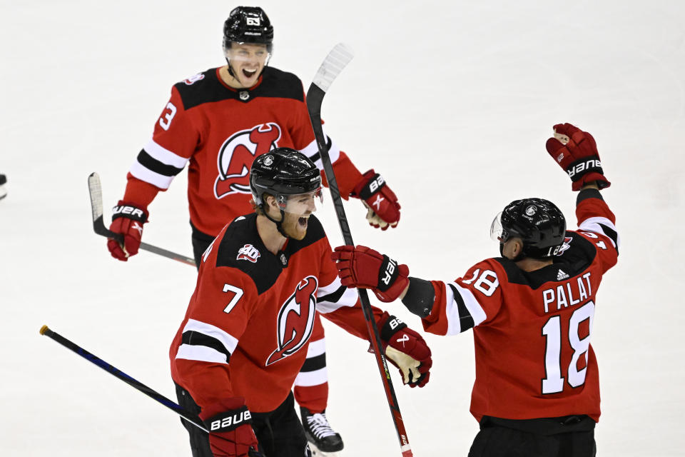 New Jersey Devils defenseman Dougie Hamilton (7) celebrates after his goal with Ondrej Palat (18) and Jesper Bratt (63) during the third period of an NHL hockey game against the Seattle Kraken, Thursday, Feb. 9, 2023, in Newark, N.J. (AP Photo/Bill Kostroun)