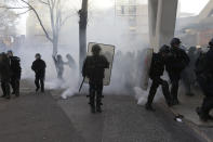 French police take positions in a cloud of tear gas during a yellow vest protest in Marseille, southern France, Saturday, Jan. 12, 2019. Paris brought in armored vehicles and the central French city of Bourges shuttered shops to brace for new yellow vest protests. The movement is seeking new arenas and new momentum for its weekly demonstrations. Authorities deployed 80,000 security forces nationwide for a ninth straight weekend of anti-government protests. (AP Photo/Claude Paris)