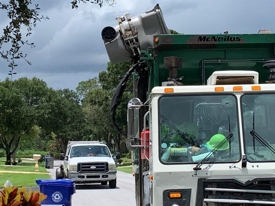 A Waste Management truck unloads garbage from a container at a home in South Indian River County on Tuesday, July 18, 2023.