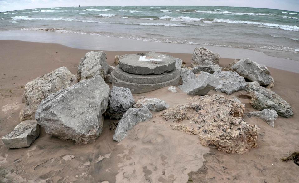 A view showing a sewage infrastructure manhole cover shored up with rocks to protect it from high Lake Michigan waters near King Park, Thursday, October 28, 2021, in Sheboygan, Wis.
