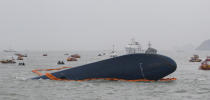 South Korean Coast Guard officers search for missing passengers aboard a sunken ferry in the water off the southern coast near Jindo, South Korea, Thursday, April 17, 2014. Strong currents, rain and bad visibility hampered an increasingly anxious search Thursday for more than 280 passengers still missing a day after their ferry flipped onto its side and sank in cold waters off the southern coast of South Korea.(AP Photo/Ahn Young-joon)