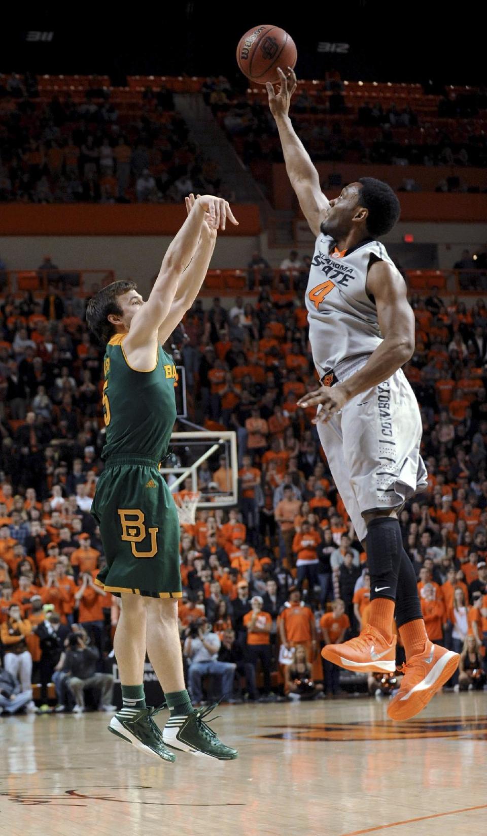 Oklahoma State forward Brian Williams, right, blocks the shot of Baylor guard Brady Heslip during the first half of an NCAA college basketball game in Stillwater, Okla., Saturday, Feb. 1, 2014. Baylor won 76-70. (AP Photo/Brody Schmidt)